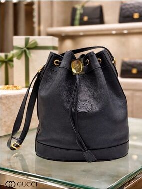 AUTHENTIC GUCCI SMOKY BLACK LEATHER DRAWSTRING BUCKET BAG GOLD LOGO CLOSURE.